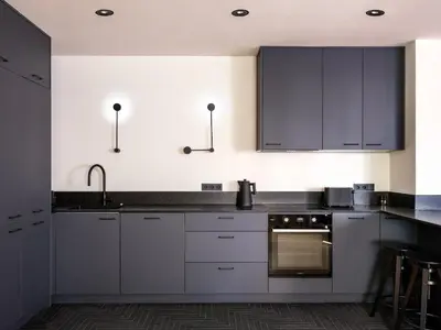 a kitchen with white cabinets and an oven at Tyzenhauz Villas in Kraków