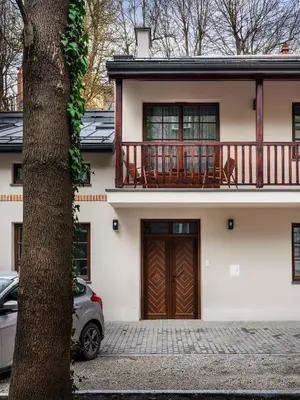 a house with a wooden door and a balcony at Tyzenhauz Villas in Kraków