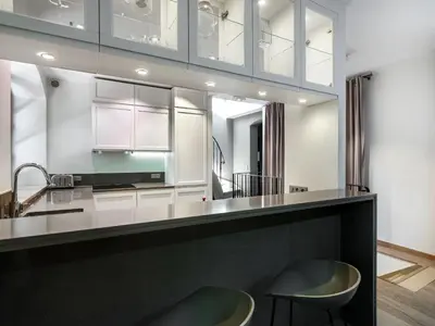 a kitchen with a counter and two stools at Tyzenhauz Villas in Kraków