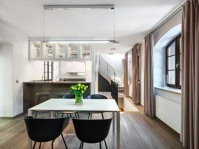 a dining room and kitchen with a table and chairs at Tyzenhauz Villas in Kraków
