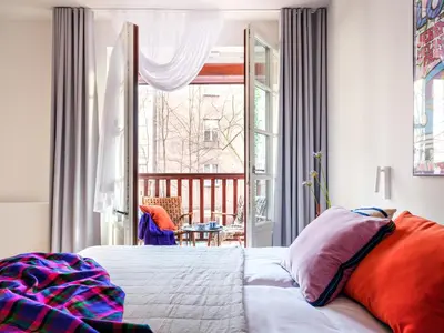 a bedroom with a bed with a colorful blanket on it at Tyzenhauz Villas in Kraków