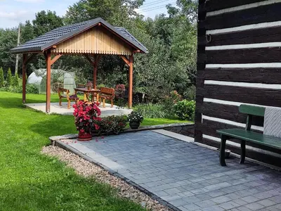 a gazebo with a bench and a picnic table at Gryglówka Noclegi in Zembrzyce