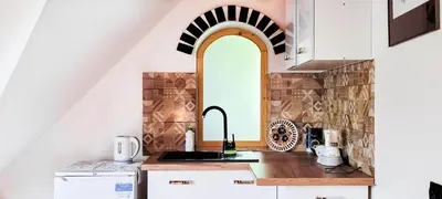 a kitchen with a sink and an archway at Gryglówka Noclegi in Zembrzyce