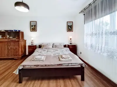 a bedroom with a bed and a large window at Gryglówka Noclegi in Zembrzyce