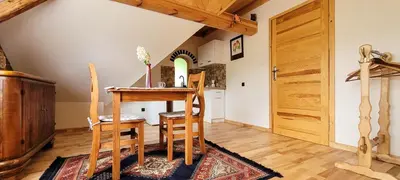 a dining room with a wooden table and chairs at Gryglówka Noclegi in Zembrzyce