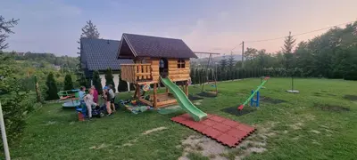 a group of people standing next to a playground at Domek Nad Stawem I in Limanowa