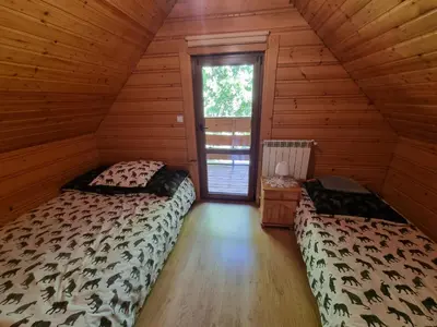 a bedroom with two beds in a log cabin at Domek Nad Stawem I in Limanowa