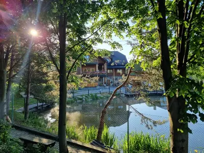 a park with a lake and a building in the background at Domek Nad Stawem I in Limanowa