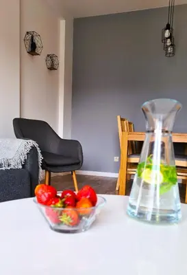 a glass vase sitting on a table with a bowl of fruit at Taboo by Housine in Zator