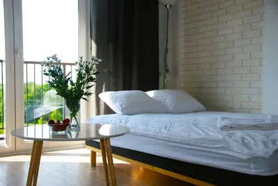 a bedroom with a bed and a table and a window at Taboo by Housine in Zator
