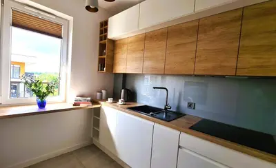 a kitchen with wooden cabinets and a sink and a window at Taboo by Housine in Zator