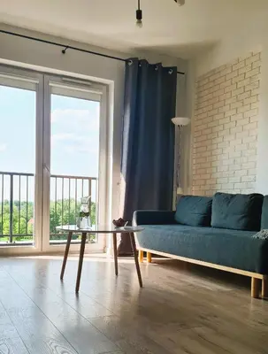 a living room with a blue couch and a glass table at Taboo by Housine in Zator