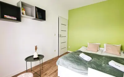 a bedroom with a green wall and a bed with a table at Taboo by Housine in Zator