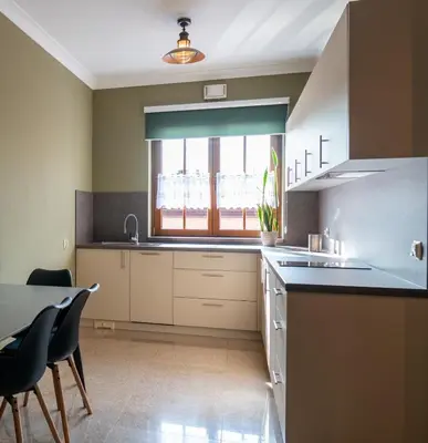 a kitchen with a sink and a table with chairs at APARTAMENT Piłsudskiego13 Chrzanów in Chrzanów