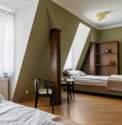 a bedroom with two beds and a table with a chair at APARTAMENT Piłsudskiego13 Chrzanów in Chrzanów