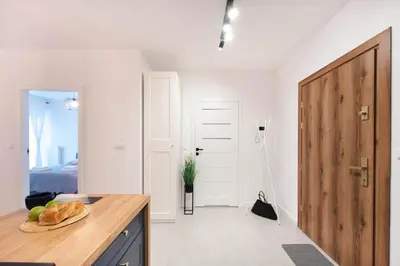 a kitchen with a table and a wooden door at Spacious and modern Apartment Lwowska, close to Kazimierz in Kraków