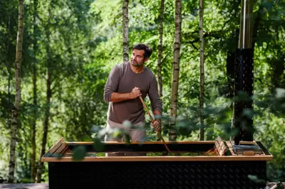 a man standing in front of a barbecue grill at Bukowy Las in Lipnica Górna