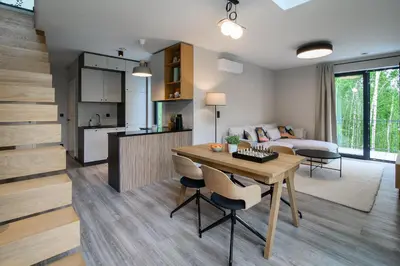 a kitchen and living room with a wooden table in a room at Bukowy Las in Lipnica Górna