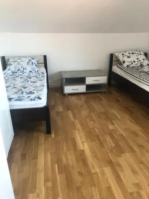 a room with two beds and a wooden floor at Wypoczynek nad Dunajcem in Jurków