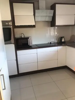 a kitchen with white cabinets and a microwave at Wypoczynek nad Dunajcem in Jurków