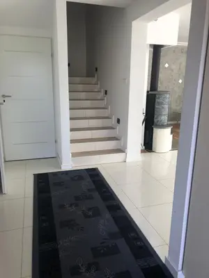 a hallway with stairs and a rug on the floor at Wypoczynek nad Dunajcem in Jurków
