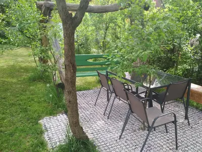 a green picnic table and chairs next to a tree at Domek w Bieńkówce in Bieńkówka