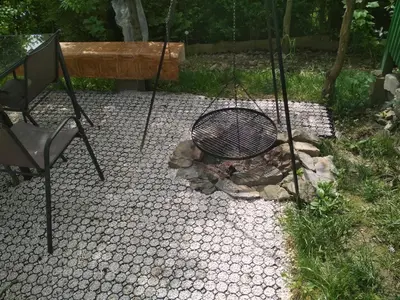 a chair and a fire pit in a garden at Domek w Bieńkówce in Bieńkówka