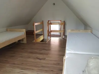 a attic room with two beds and a mirror at Domek w Bieńkówce in Bieńkówka