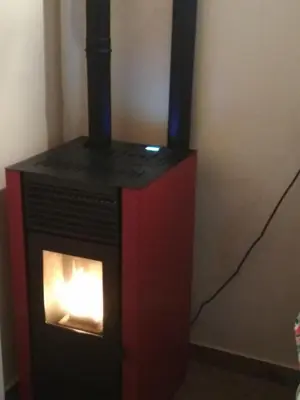 a black and red stove with a fire in it at Domek w Bieńkówce in Bieńkówka