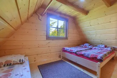 a room with a bed in a log cabin at Osada Pod Turbaczem in Nowy Targ