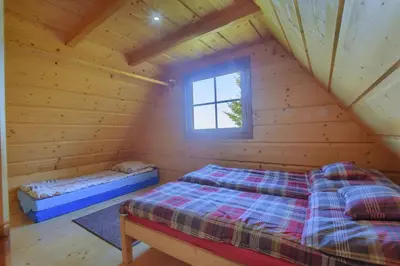 a bedroom with two beds in a log cabin at Osada Pod Turbaczem in Nowy Targ