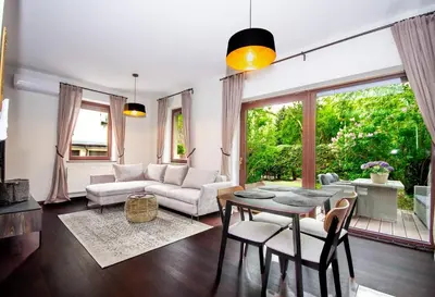 a living room with a couch and a table and chairs at InPoint 2-bedrooms Apartment with private garden and free parking in Kraków