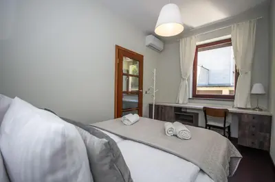 a bedroom with a bed and a desk and a window at InPoint 2-bedrooms Apartment with private garden and free parking in Kraków
