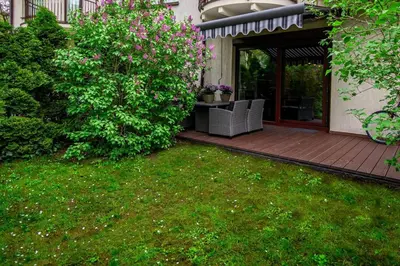 a yard with a wooden deck with a chair on it at InPoint 2-bedrooms Apartment with private garden and free parking in Kraków
