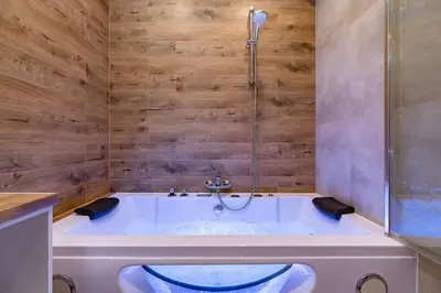 a bath tub in a bathroom with a shower at Luxurious Apartment Rakowicka Kraków by Renters Prestige in Kraków