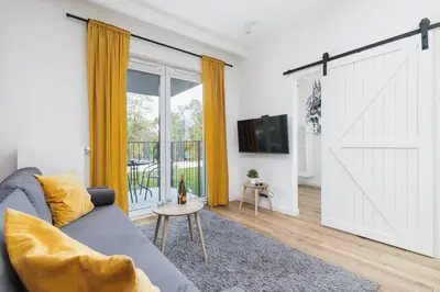 a living room with a large sliding barn door at Luxurious Apartment Rakowicka Kraków by Renters Prestige in Kraków