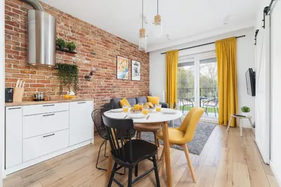 a kitchen and dining room with a brick wall at Luxurious Apartment Rakowicka Kraków by Renters Prestige in Kraków