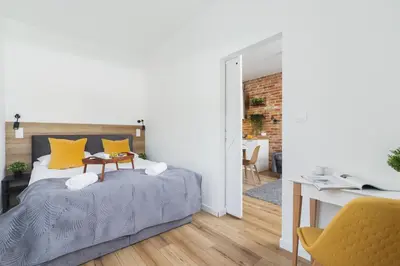 a bedroom with a bed with yellow pillows and a desk at Luxurious Apartment Rakowicka Kraków by Renters Prestige in Kraków