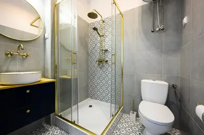 a bathroom with a shower and a toilet and a sink at Wiślna Main Square Apartments in Kraków