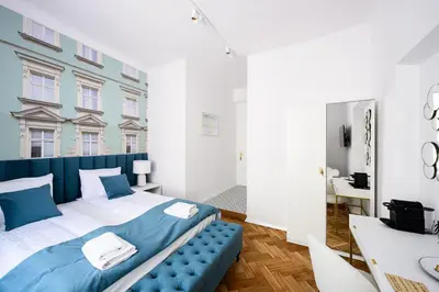 a bedroom with a large bed with a blue bench at Wiślna Main Square Apartments in Kraków