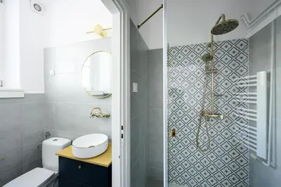 a bathroom with a shower with a toilet and a sink at Wiślna Main Square Apartments in Kraków