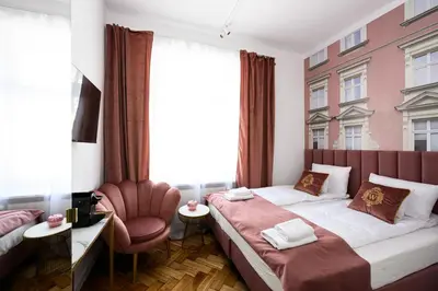 a hotel room with two beds and a chair at Wiślna Main Square Apartments in Kraków