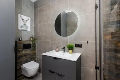 a bathroom with a sink and a toilet and a mirror at Basztowa Apartments by VSI in Kraków