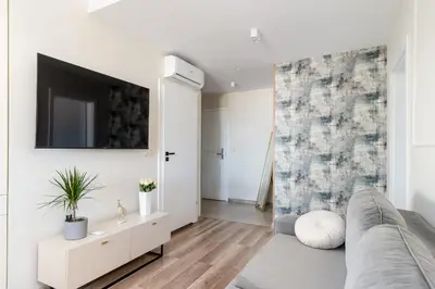 a living room with a couch and a tv on a wall at Basztowa Apartments by VSI in Kraków