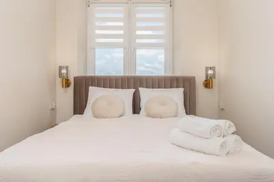 a bed with white pillows and towels on it at Basztowa Apartments by VSI in Kraków