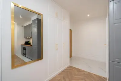 a hallway with a mirror and a kitchen at Exclusive Royal Apartment in Kraków