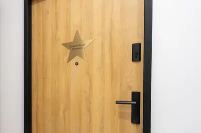 a star on a wooden door with a sign on it at Exclusive Royal Apartment in Kraków