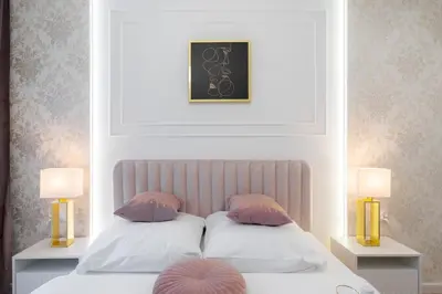 a bedroom with two pillows on a bed with two lamps at Exclusive Royal Apartment in Kraków