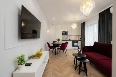 a living room with a red couch and a table at Exclusive Crystal Apartment in Kraków