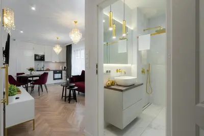 a white bathroom with a sink and a kitchen at Exclusive Crystal Apartment in Kraków